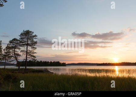 Il sole di mezzanotte presso il lago Inari In Finaland in Lapponia in Scandinavia Foto Stock