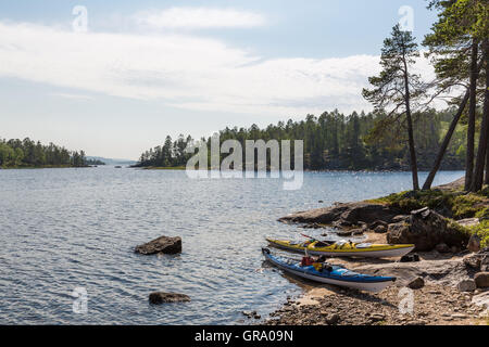 Due kayak da mare sulla riva del lago Inari nel nord della Lapponia in Finlandia Foto Stock