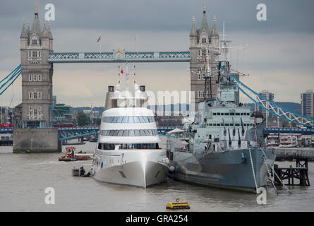 Un 390ft motor yacht appartenente al magnate russo Andrey Melnichenko, a fianco di HMS Belfast (destra) sul Fiume Tamigi a Londra. Foto Stock