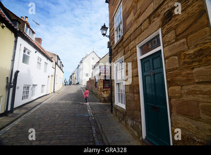 Una ripida strada acciottolata a Whitby, North Yorkshire, Regno Unito Foto Stock