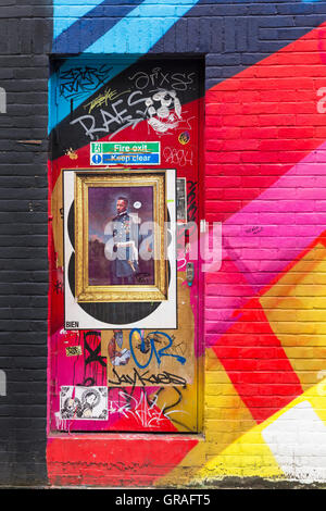 I graffiti sulla porta con foto incorniciate e murale colorato graffiti sul muro a Shoreditch, Londra nel mese di settembre Foto Stock