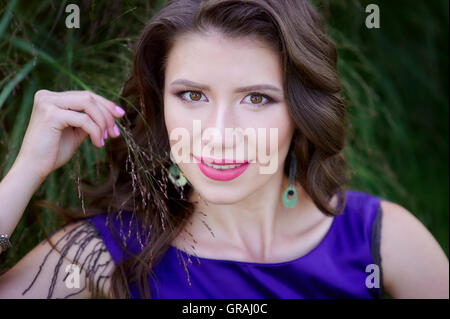 Bella donna giacente su erba verde nel parco Foto Stock