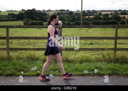 Runner di acqua potabile in The Kenilworth mezza maratona, Warwickshire, Regno Unito Foto Stock