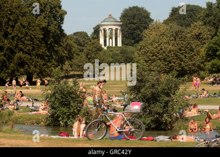 Prato affollato durante l'ondata di caldo in Englischer Garten con Monopteros a Monaco di Baviera Foto Stock