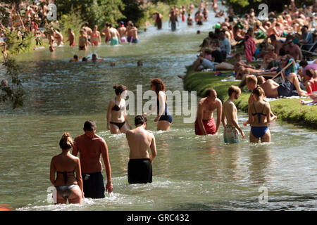 Affollato di Prato e Eisbach durante l'ondata di caldo in Englischer Garten a Monaco di Baviera Foto Stock