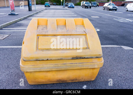 Un giallo graniglia di plastica bin in un parcheggio, UK. Foto Stock