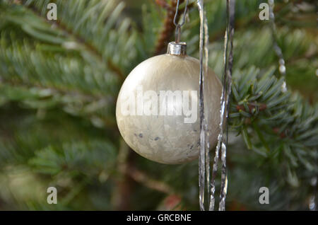 Albero di Natale Decorazioni, sfera di vetro e Tinsel sul ramo di abete Foto Stock