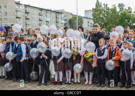 NOVOKUZNETSK, Kemerovo Regione, RUSSIA - SEP, 1, 2016: Incontro con il primo grado gli alunni e gli insegnanti a schoolyard. Il giorno della Foto Stock