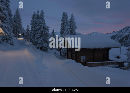 Paesaggio, profondamente coperta di neve, con abeti e Chalet, all'alba Foto Stock