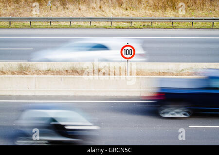 Segno del limite di velocità in autostrada traffico passante Foto Stock