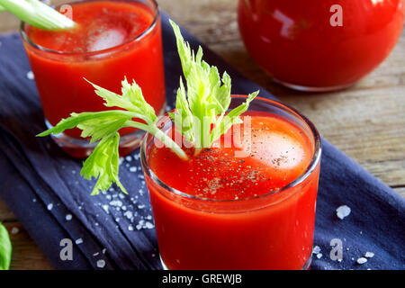 I succhi di pomodoro con sedano, spezie, sale e ghiaccio nella porzione bicchieri. Bloody Mary cocktail. Foto Stock