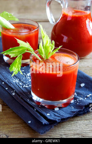 I succhi di pomodoro con sedano, spezie, sale e ghiaccio nella porzione bicchieri. Bloody Mary cocktail. Foto Stock