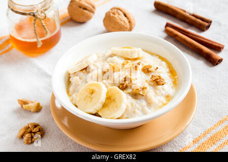 Fresco del porridge di fiocchi d'avena con banana, noci e miele per una sana prima colazione Foto Stock