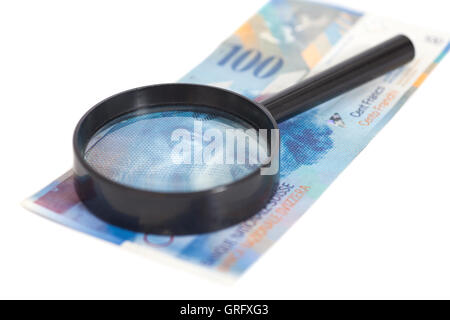 Swiss 100 le banconote in franchi sotto la lente di ingrandimento isolati su sfondo bianco Foto Stock