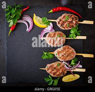 Appetitosi kebab kofta (polpette di carne) su sfondo nero. Vista superiore Foto Stock
