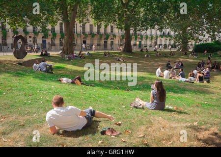 Fitzroy Square London, vista della gente che si rilassa nel Fitzroy Square Garden in un pomeriggio estivo, Londra, Inghilterra, Regno Unito. Foto Stock