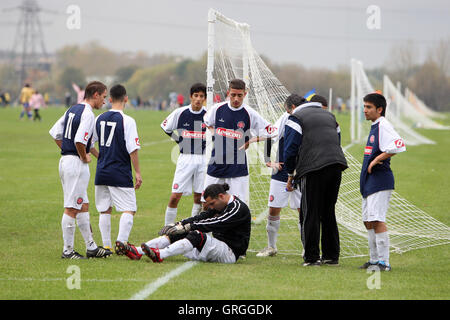 White Hart Rapids FC giocatori mostrano la loro preoccupazione per un team mate infortunato durante un est di Londra domenica League a Hackney ma Foto Stock