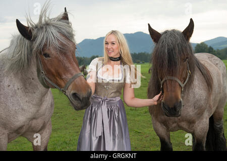 Sindeldorf, Germania. Il 29 agosto, 2016. Attenzione periodo di bloccaggio: 8 settembre 2016, 12 AM/dpa esclusivo: La Wiesn playmate Kathie Kern in posa con la fabbrica di birra cavalli a Urthalerhof in sindeldorf, Germania, 29 agosto 2016. Il Wiesnplaymate 2016 da un piccolo villaggio di montagna ha visitato il "horse power' che tira la birra pesanti carri presso la più grande fiera del divertimento nel mondo, l'Oktoberfest. Foto: FELIX HOERHAGER/dpa/Alamy Live News Foto Stock