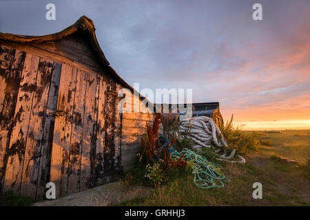 Capovolti barche di pescatori sulla spiaggia di sunrise, Lindisfarne Isola Santa Northumberland REGNO UNITO Foto Stock