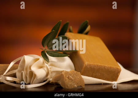 Olio di oliva il sapone con un asciugamano su una scrivania in legno Foto Stock