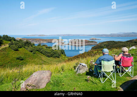 Il turista a godere di vista dal punto di vista Drumbeg verso Eddrachilis Bay,Sutherland, Scotland, Regno Unito Foto Stock