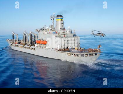 Un US Navy MH-60S Sea Hawk elicottero ascensori forniture dalla flotta oliatore di rifornimento USNS Big Horn durante un rifornimento in mare con l'assalto anfibio nave USS Wasp Luglio 23 nel Mar Mediterraneo. Foto Stock