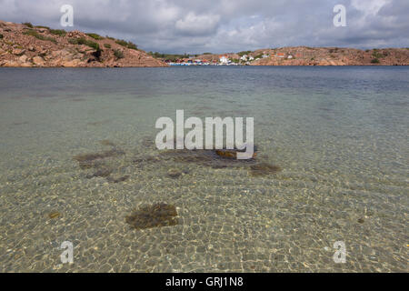 Giorno di estate a nord Grundsund fuori da Getholmen con acqua poco profonda nella parte anteriore. Acque poco profonde in una lagun circondata da rocce rosse! Foto Stock