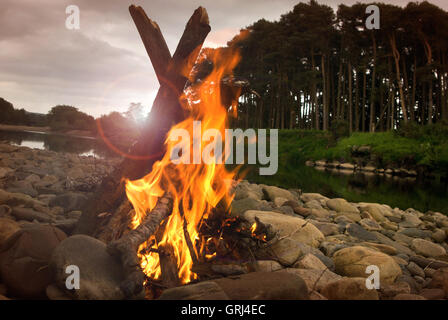 Campo di fuoco su un riverside spiaggia ghiaiosa Foto Stock