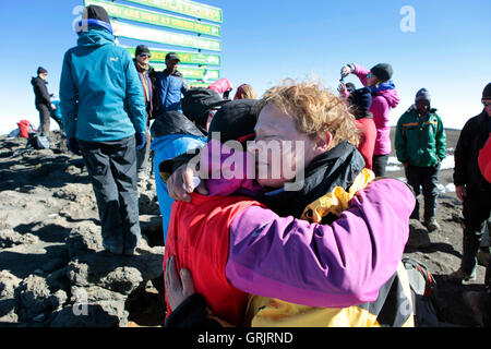 Due donne gli escursionisti sono pianto di felicità e abbracciando sul vertice di Kilimanjaro. Foto Stock