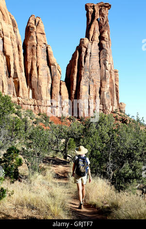 Escursionista femmina al di sotto di baciare coppia monumento di pietra arenaria, Colorado National Monument, Grand Junction, Colorado, STATI UNITI D'AMERICA Foto Stock