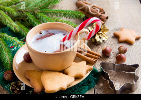 Cioccolata calda con la menta piperita candy canes e gingerbread cookie su tavola in legno rustico per le vacanze di Natale ed invernali Foto Stock