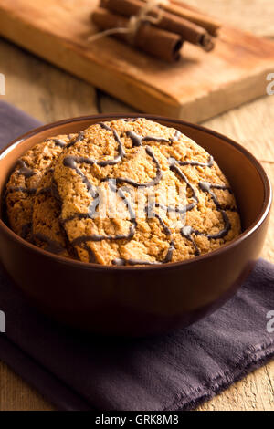 In casa i fiocchi d'avena i biscotti con la cioccolata in tazza oltre rustico sfondo di legno Foto Stock