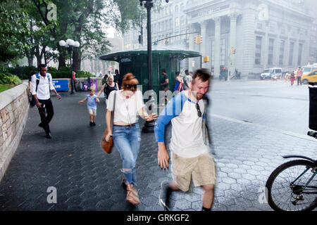 New York City,NY NYC,Manhattan,Midtown,Union Square,zona pedonale,strada trafficata,pioggia improvvisa,acquazzone,corsa,copertura,Black Blacks Africa Foto Stock