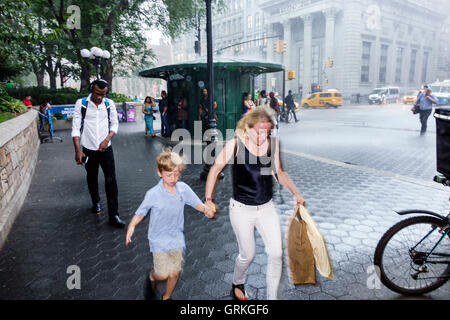 New York City,NY NYC,Manhattan,Midtown,Union Square,pedonale plaza,strada trafficata,pioggia improvvisa,corsa,presa di copertura,neri africani etnici Foto Stock