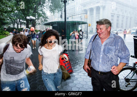 New York City,NY NYC,Manhattan,Midtown,Union Square,zona pedonale,strada trafficata,pioggia improvvisa,corsa,copertura,adulti,uomo uomo maschio,donna wome Foto Stock