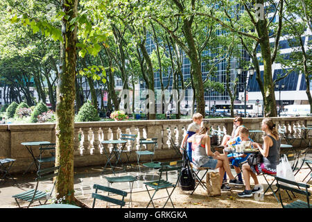 New York City,NY NYC Manhattan,Midtown,Bryant Park,parco pubblico,balaustra,posti a sedere,vegetazione,albero,adulti,donna donna donne,maschio ragazzi bambini c Foto Stock