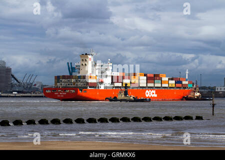 Svitzer Millgarth & Ashgarth rimorchiatori ormeggio Hong Kong OOCL BELGIO contenitore di spedizione nave, importazioni commerciali a Peel porti nel fiume Mersey, Liverpool, Merseyside, Regno Unito Foto Stock