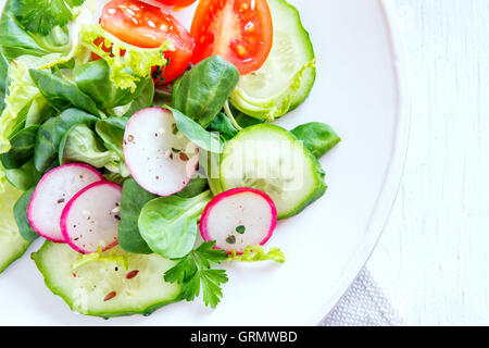 Fresco verde primavera insalata di verdure con il cetriolo, Rafano, pomodori e semi Foto Stock