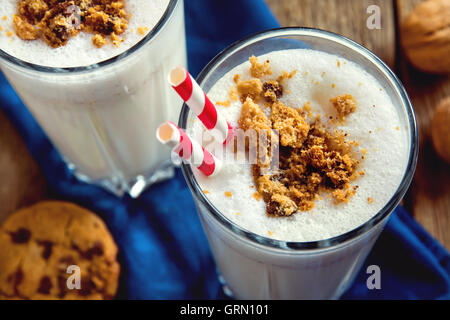Frullato di fatti in casa con scaglie di cioccolato i cookie e i dadi su tavola in legno rustico close up Foto Stock