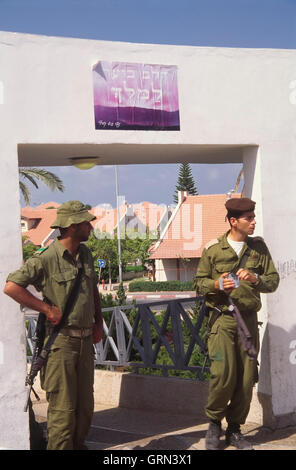 Striscia di Gaza evacuazione ("il disimpegno"), 2005 - Foto storiche. un ufficiale e un soldato di guardia alla sinagoga evacuato della Neve Dekalim insediamento. Il segno sopra le loro teste dice in ebraico "Il cuore è in fiamme per signore" Foto Stock