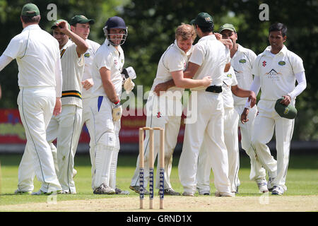 Sarfaraz Ahmed di Harold Wood celebra l ultima Wanstead paletto con i suoi compagni di squadra - Wanstead CC vs Harold Wood CC - Essex Cricket League - 07/06/14 Foto Stock