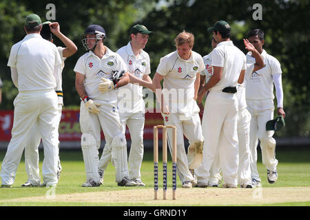 Sarfaraz Ahmed di Harold Wood celebra l ultima Wanstead paletto con i suoi compagni di squadra - Wanstead CC vs Harold Wood CC - Essex Cricket League - 07/06/14 Foto Stock