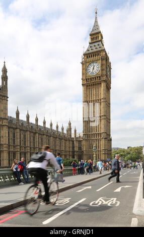 Un ciclista (sfumata attraverso la velocità) a Londra il nuovo ciclo super-autostrada sul Westminster Bridge passa il Big Ben evitando un pedone Foto Stock