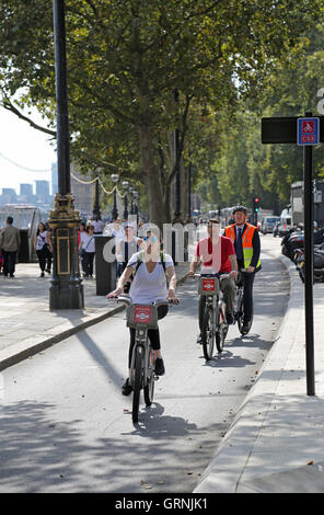 Ciclisti di Londra è di nuovo, completamente segregate est-ovest di ciclismo super-autostrada sulla Victoria Embankment. A cavallo noleggiato " Boris' bike Foto Stock