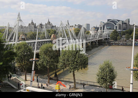 Vista di Hungerford railway e piedi ponti da sud che mostra il fiume Tamigi e il South Bank e la stazione di Charing Cross. Foto Stock