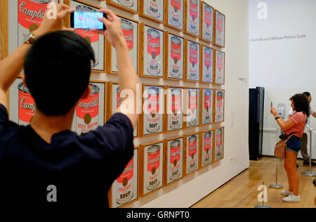 I visitatori di prendere il cellulare foto di Campbell's Soup lattine (1962) di Andy Warhol al Museo di Arte Moderna (MoMA),New York City,USA Foto Stock