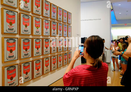 I visitatori di prendere il cellulare foto di Campbell's Soup lattine (1962) di Andy Warhol al Museo di Arte Moderna (MoMA),New York City,USA Foto Stock