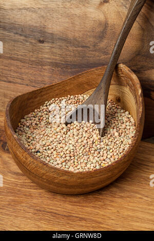 Immagine di lenticchie in una ciotola di legno. Foto Stock