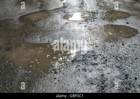 Sporco pozze su una strada sterrata. Foto Stock