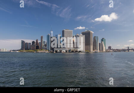 La Staten Island Ferry e Governor's Island Ferry terminali nella parte anteriore di alti edifici di uffici del centro cittadino di Manhattan. Foto Stock